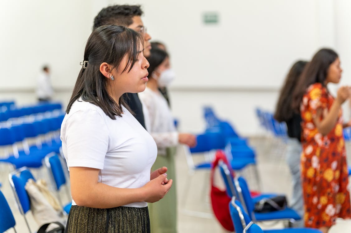 An image of a woman praying in a church.