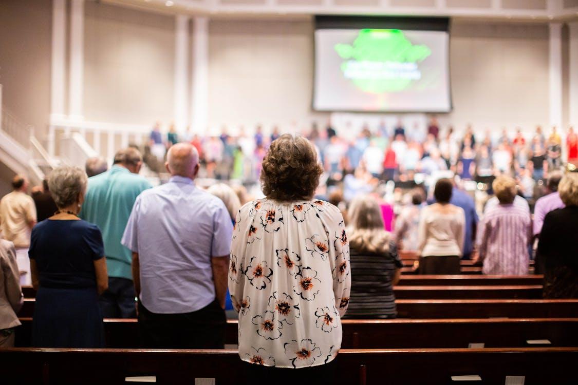 This photo shows a congregation standing in church during a service.
