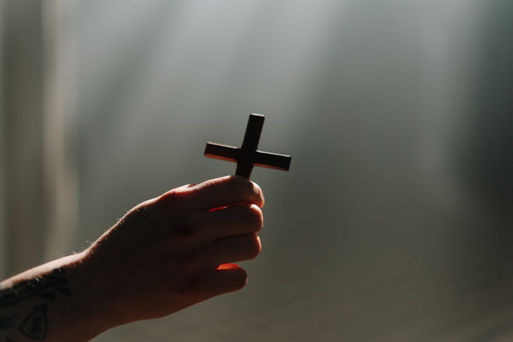 An image of a person holding a cross in their hand