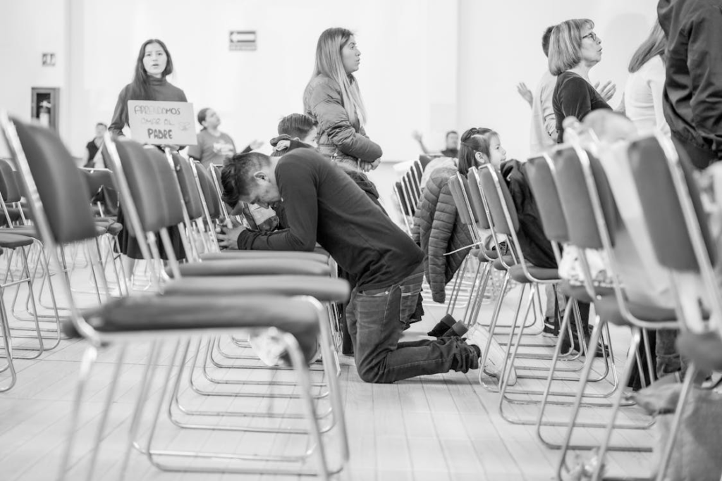 An image of a person praying while sitting down 