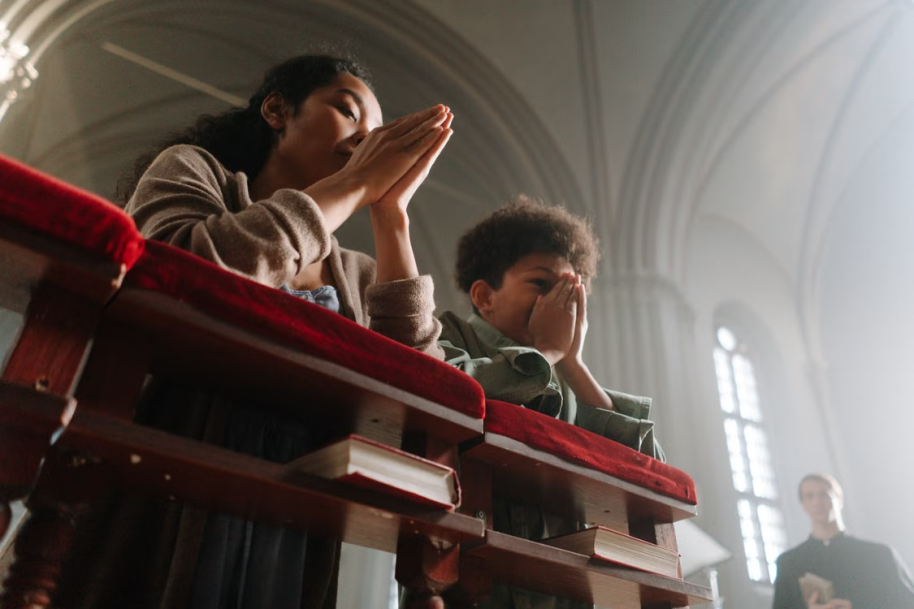 An image of a woman and her son praying in a church