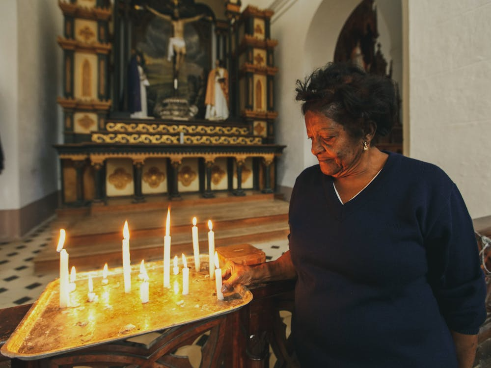 An image of a woman praying in a church