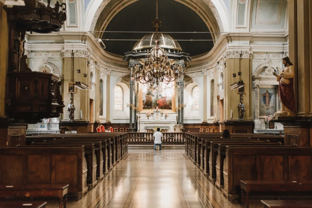 An image of a man praying in a church 
